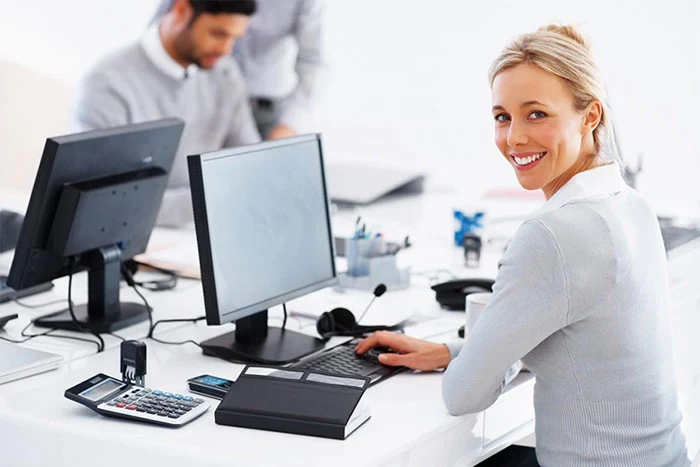 uśmiechnięta kobieta przed komputerem